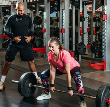 Trainer working with female client in the Strength Gym