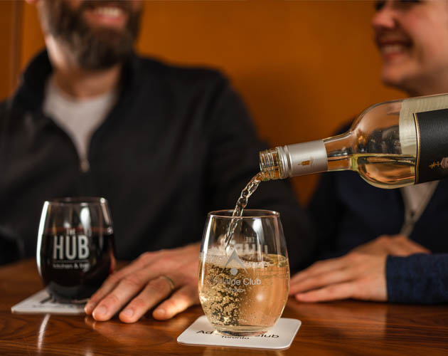 Wine being enjoyed by man and woman in the HUB