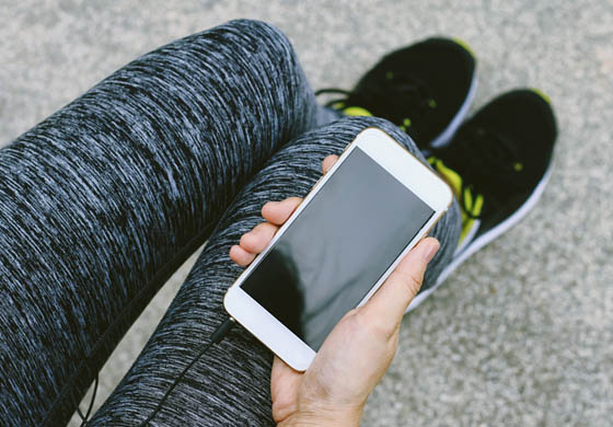 Person holding their phone with their workout gear on