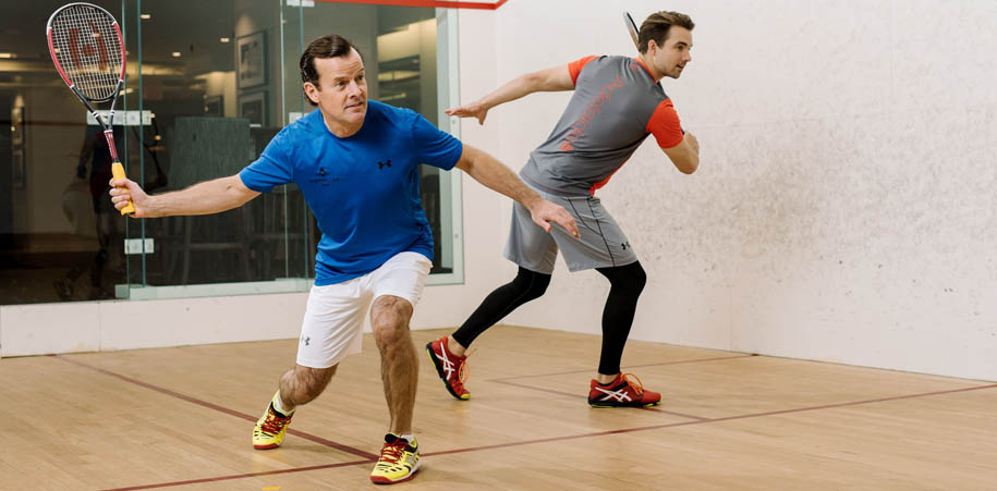 Members wearing Adelaide Club branded t-shirts playing squash