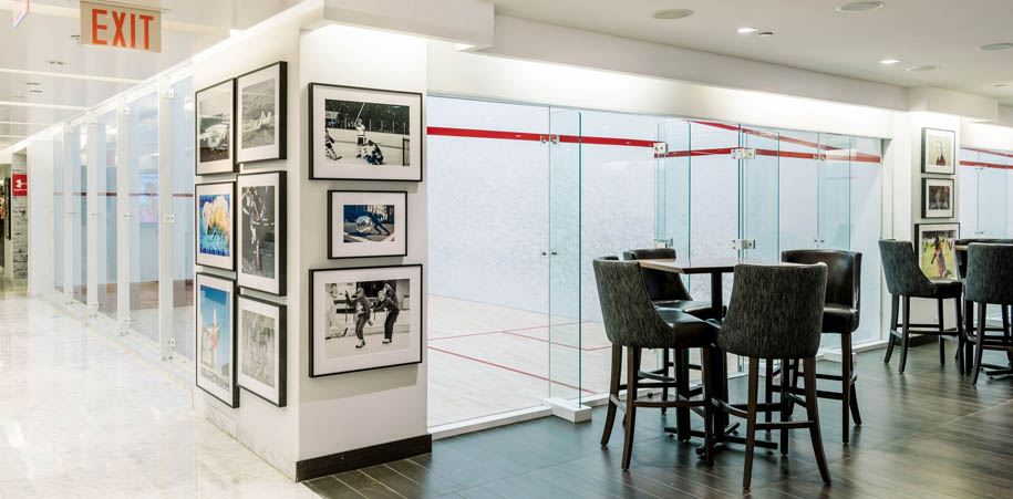 High tables in HUB lounge, in front of squash courts, surrounded by artwork and photos