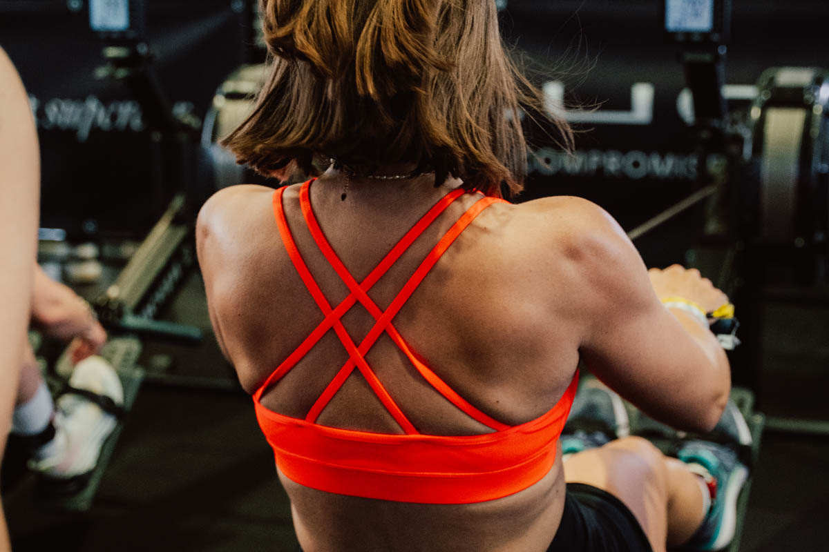 Athlete training on a rowing machine during a HYROX challenge event, building cardiovascular endurance and functional fitness for HYROX competition.
