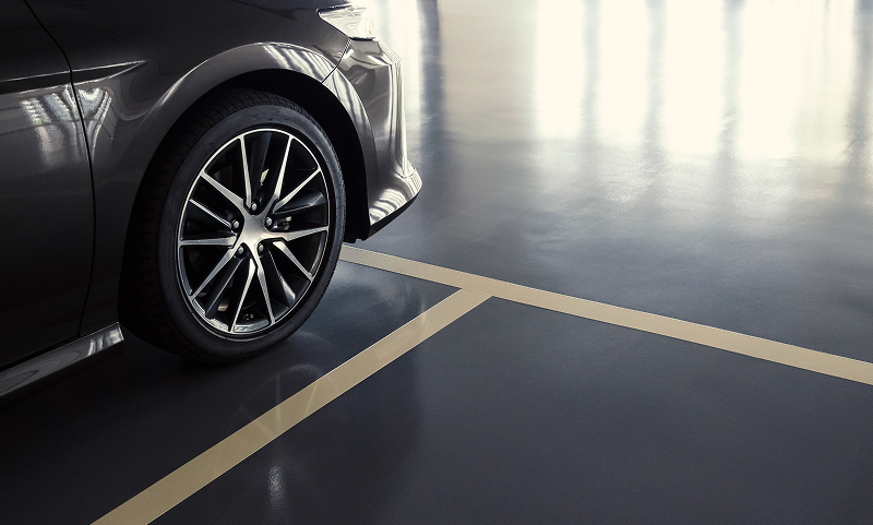 A car parked in a clean, well-lit underground parking space at the Adelaide Club.