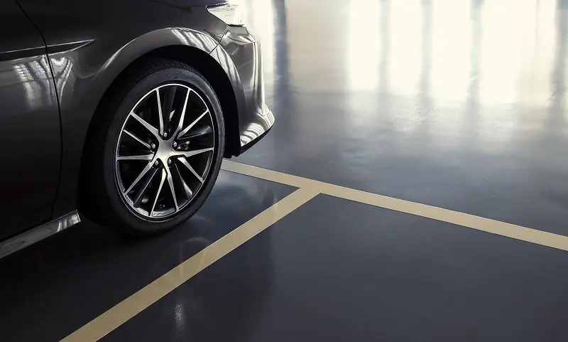 A car parked in a clean, well-lit underground parking space at the Adelaide Club.