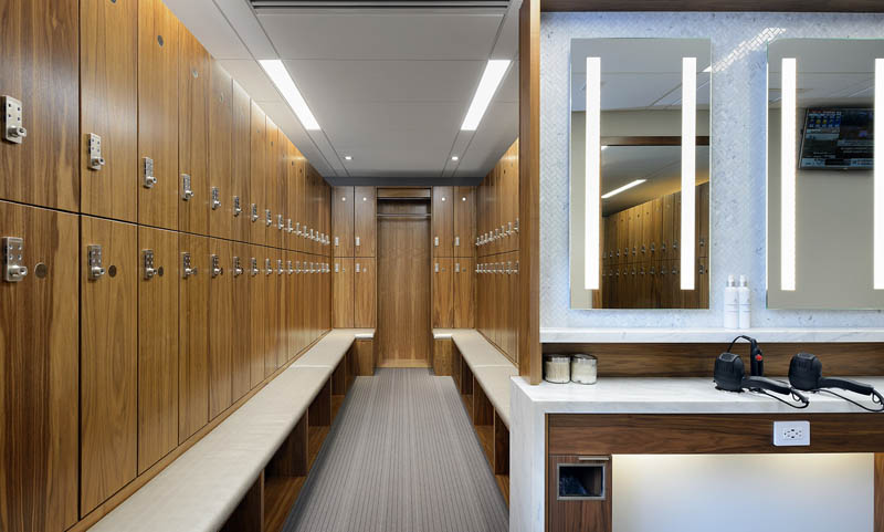 Women's locker room at the Adelaide Club featuring premium wood lockers, spacious bench seating, vanity area, and upscale fitness club amenities in downtown Toronto.