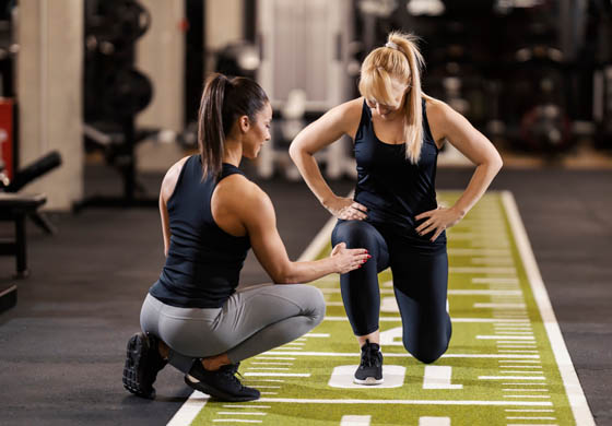 Female trainer working with a female client on the turf