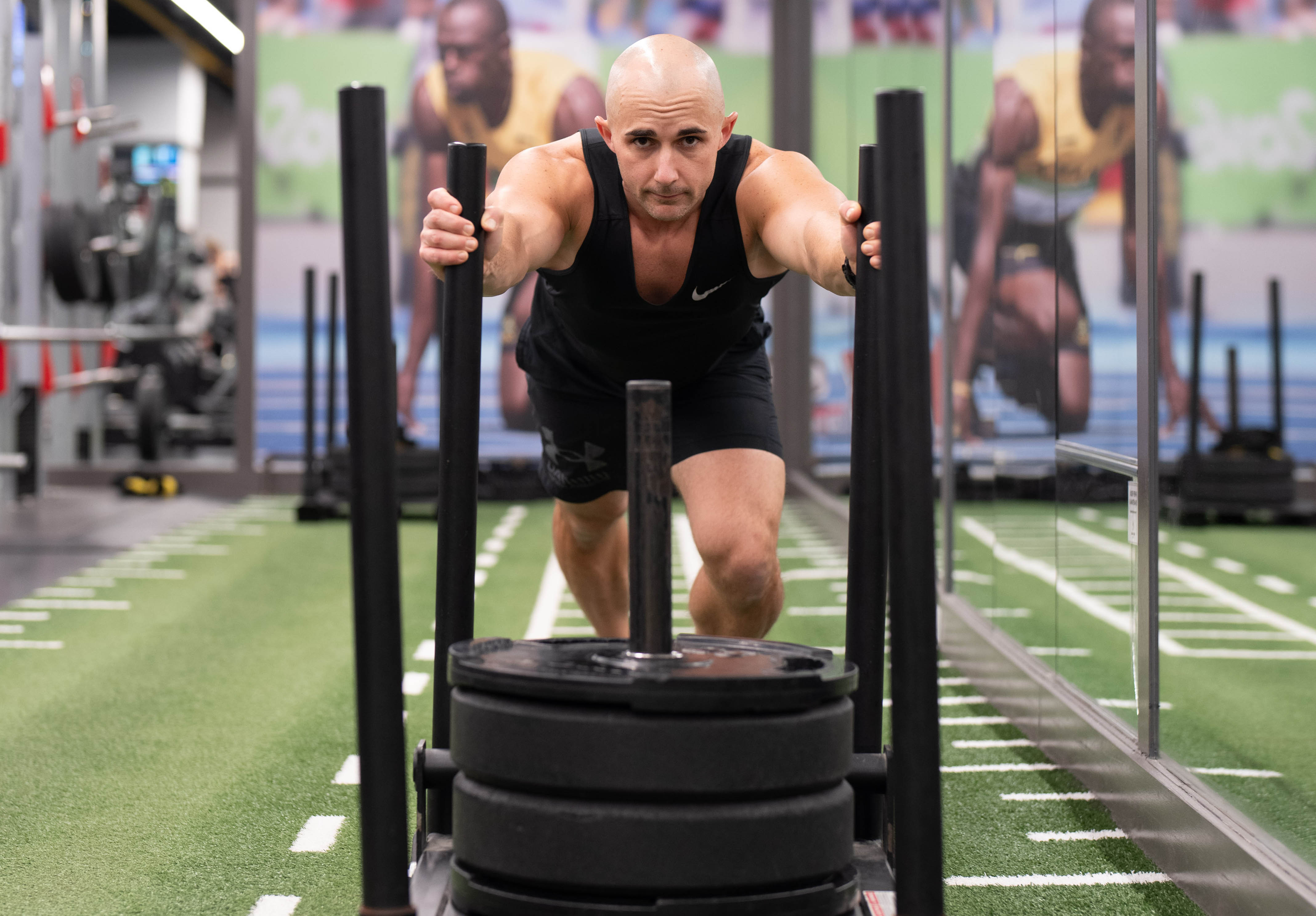 Man pushing a sled on the turf in downtown Toronto's Adelaide Club's Strength Gym