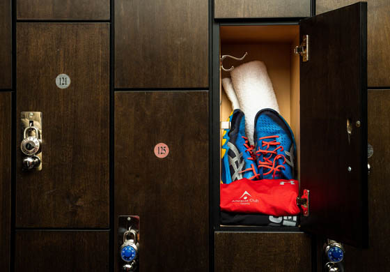 Towel, blue squash shoes, and shirt rolled up in the lockers in the men's locker room at the Adelaide Club