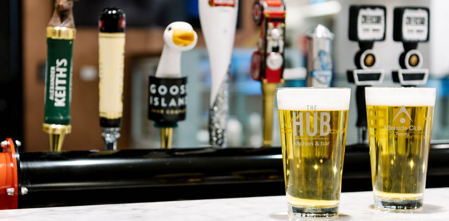 2 pints of beer on the bar at the WorkHUB, beer taps in the background